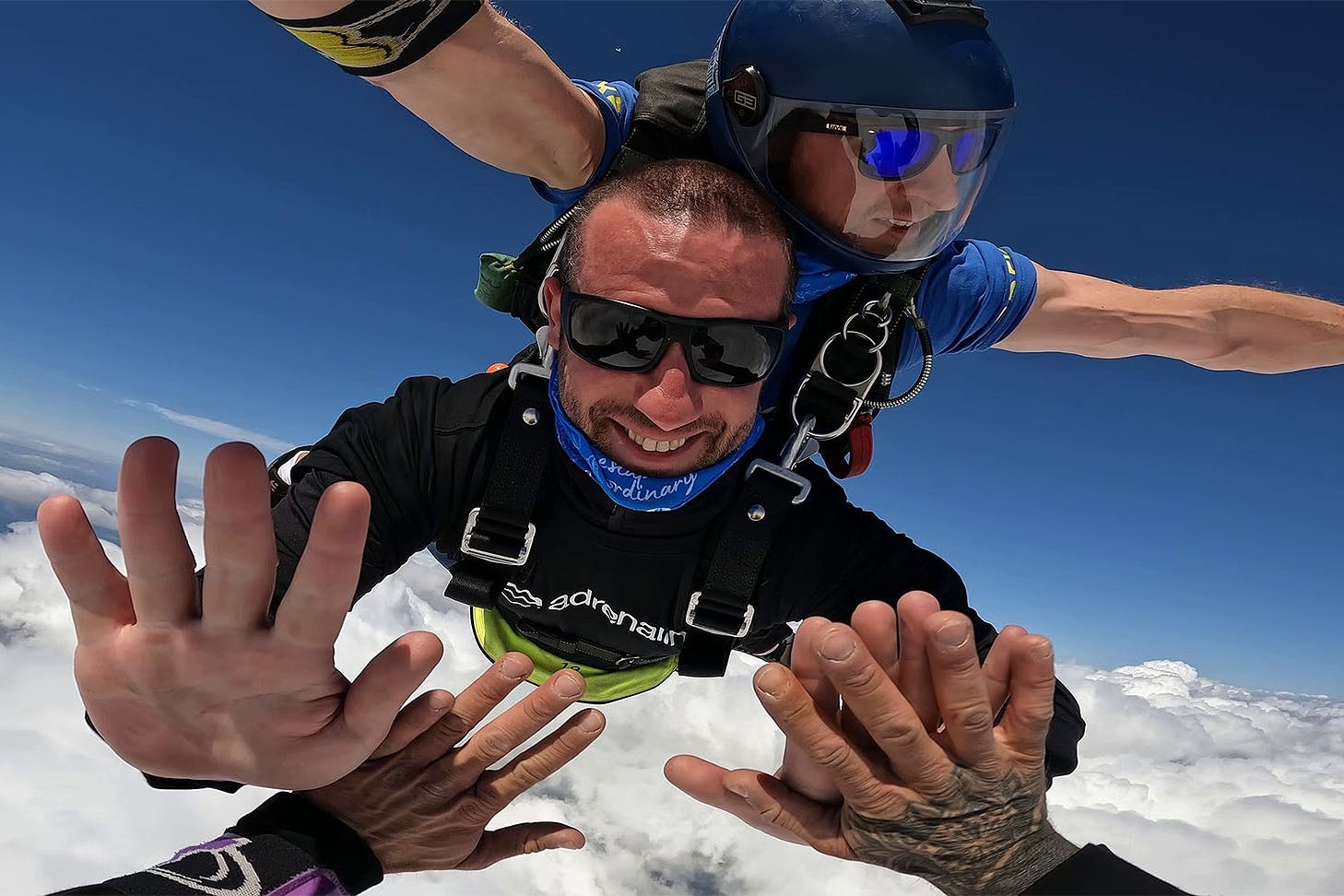 Skydivers high fiving in the sky.